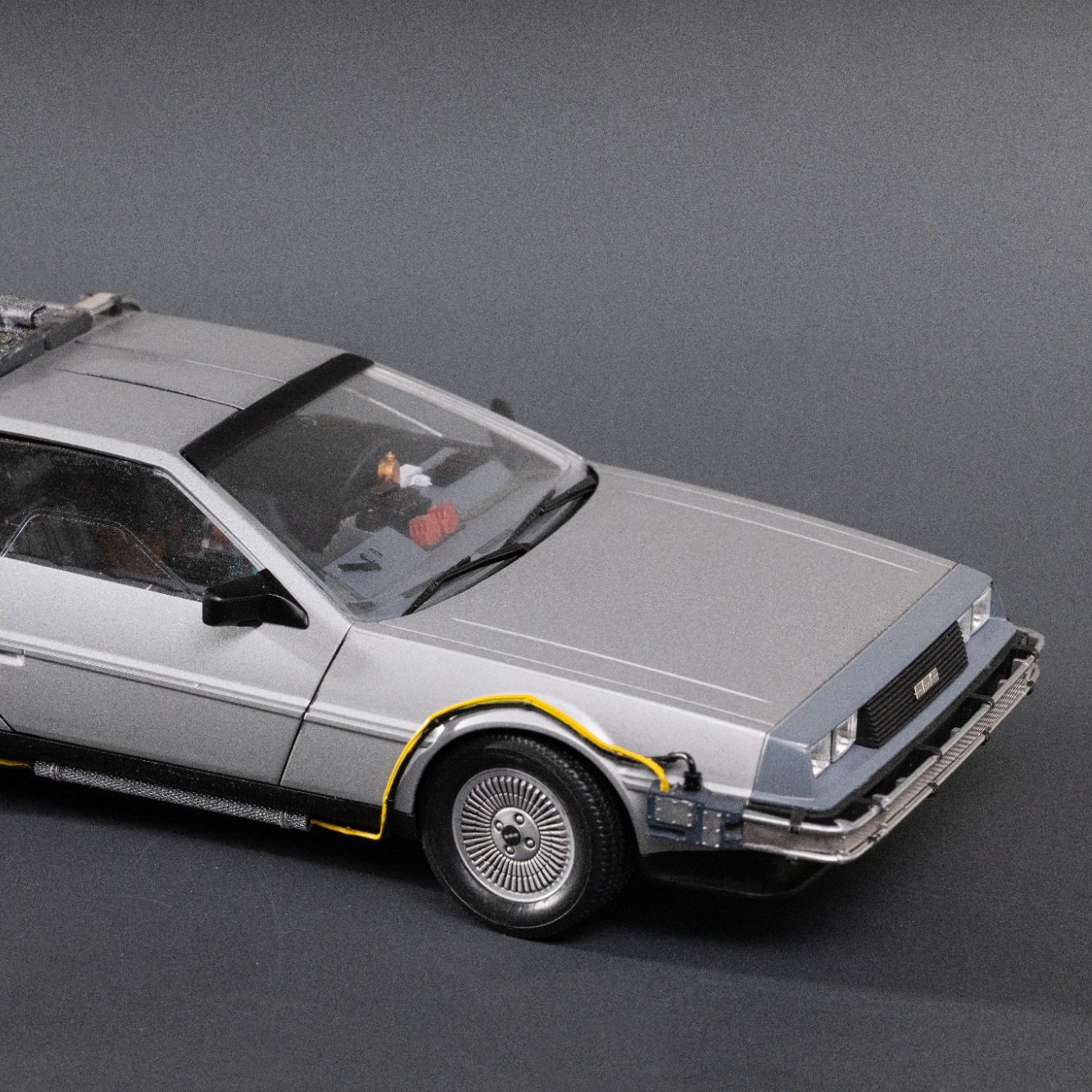 Silver model car resembling a DeLorean, featuring sleek lines and classic detailing.
