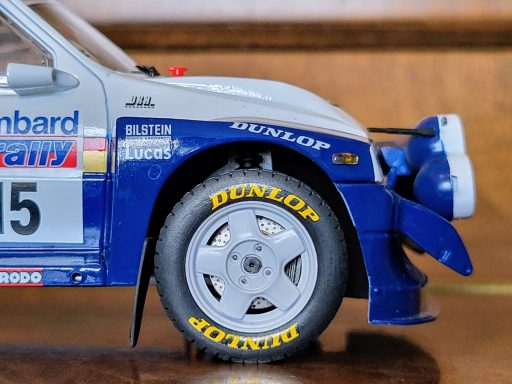 Close-up of a car’s front wheel with Dunlop tyres and detailed blue and silver paintwork.