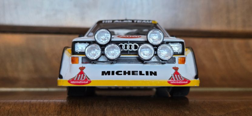 A scale model of a rally car with multiple headlights and Michelin branding.