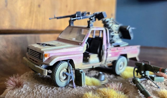 A model military vehicle equipped with a mounted machine gun and accessories.