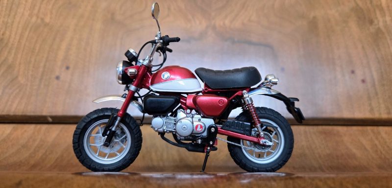 A red and silver miniature motorcycle model with a black seat.